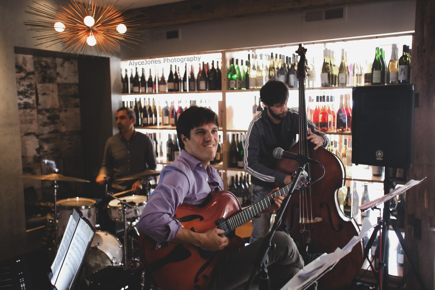 Three musicians playing jazz in a cozy bar setting.