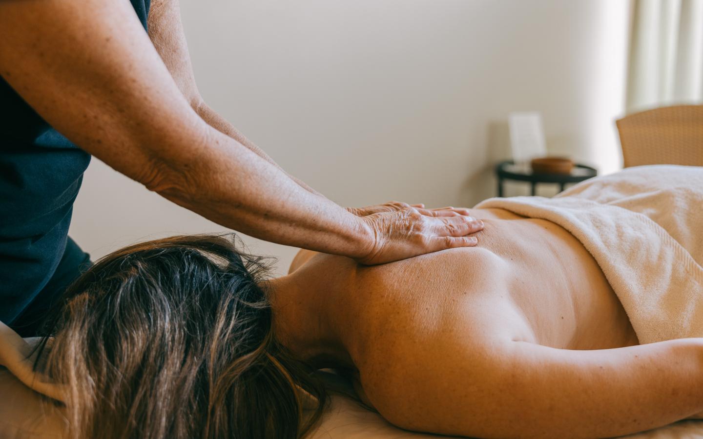 Massage therapist working on a client's back in a relaxing setting.