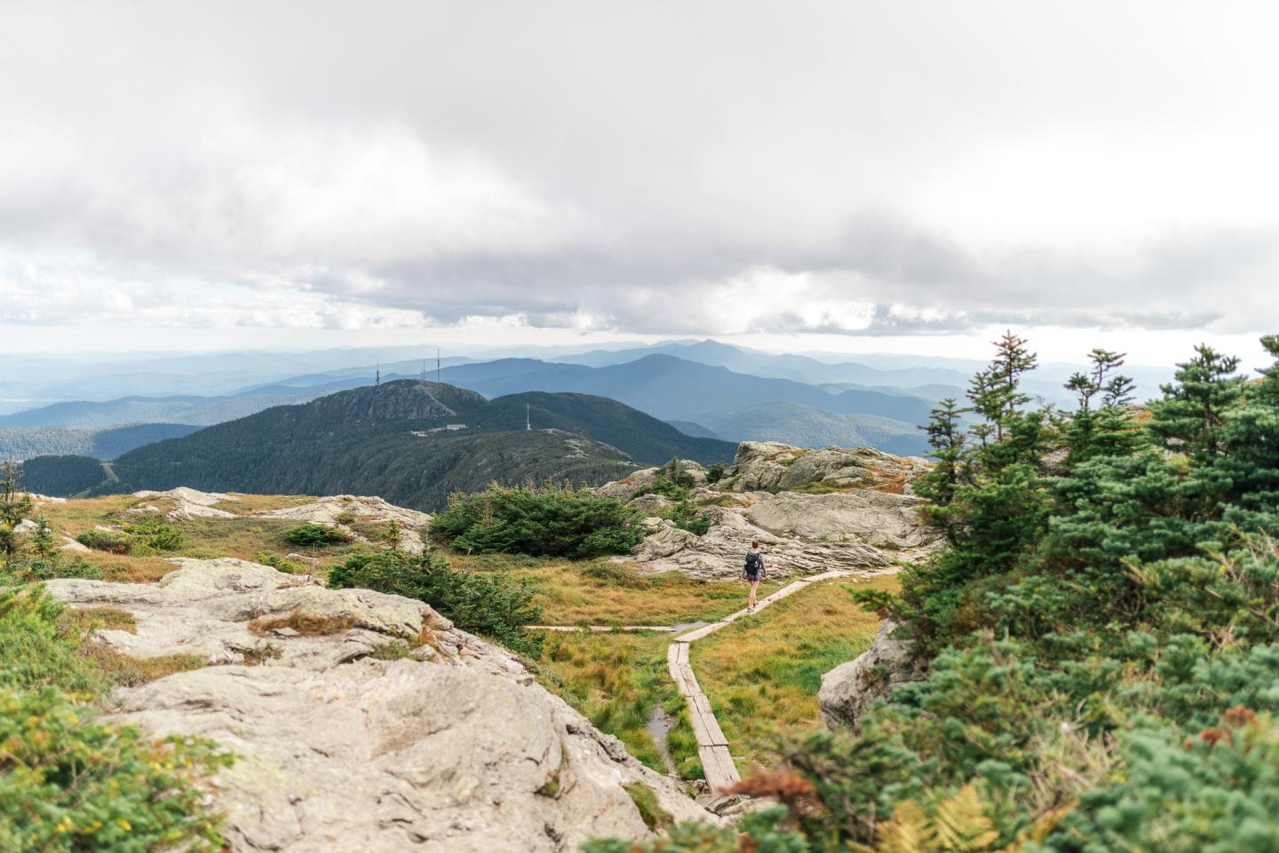 Trail on rocky mountain landscape under cloudy sky.