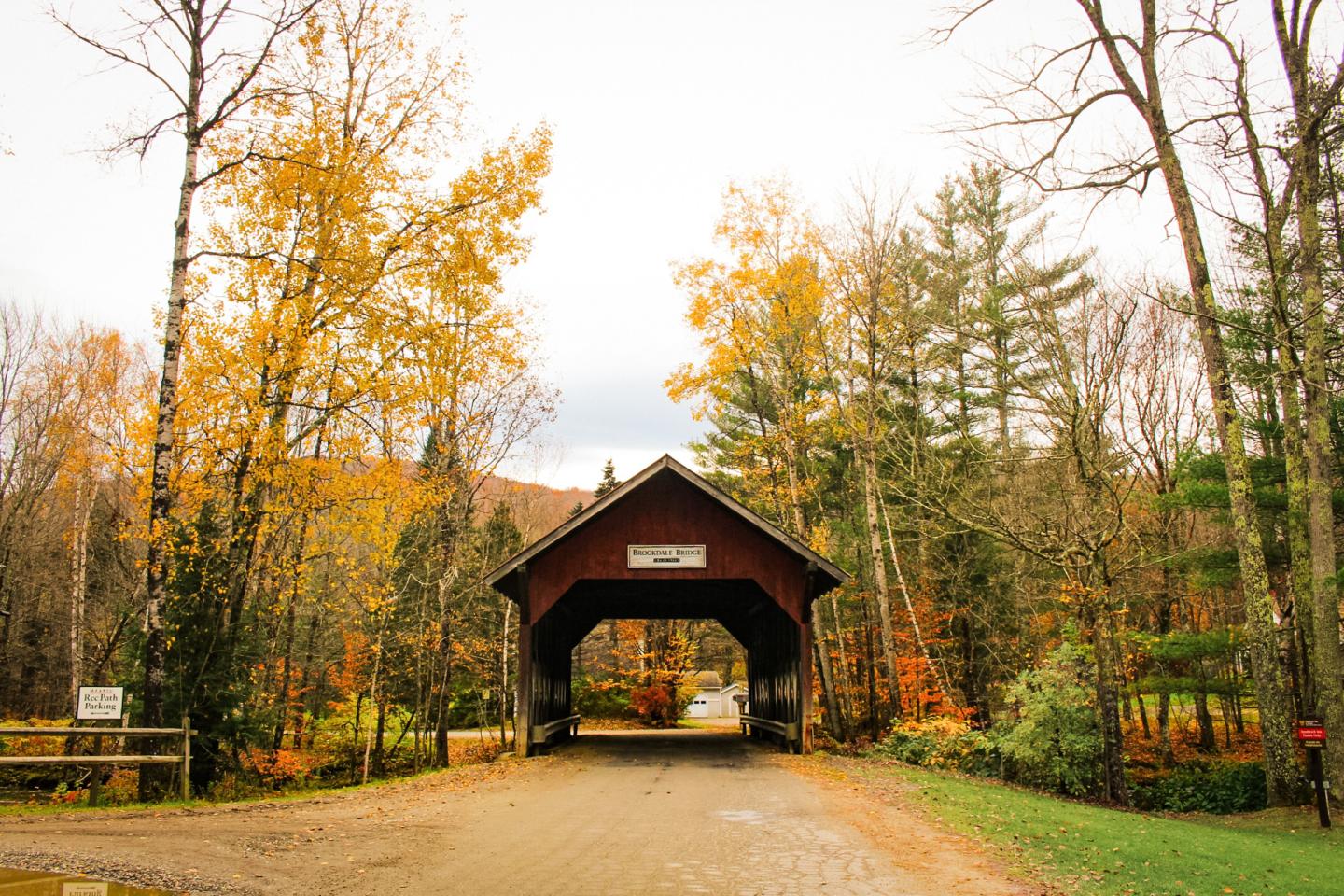 Autumn covered bridge surrounded by colorful trees.