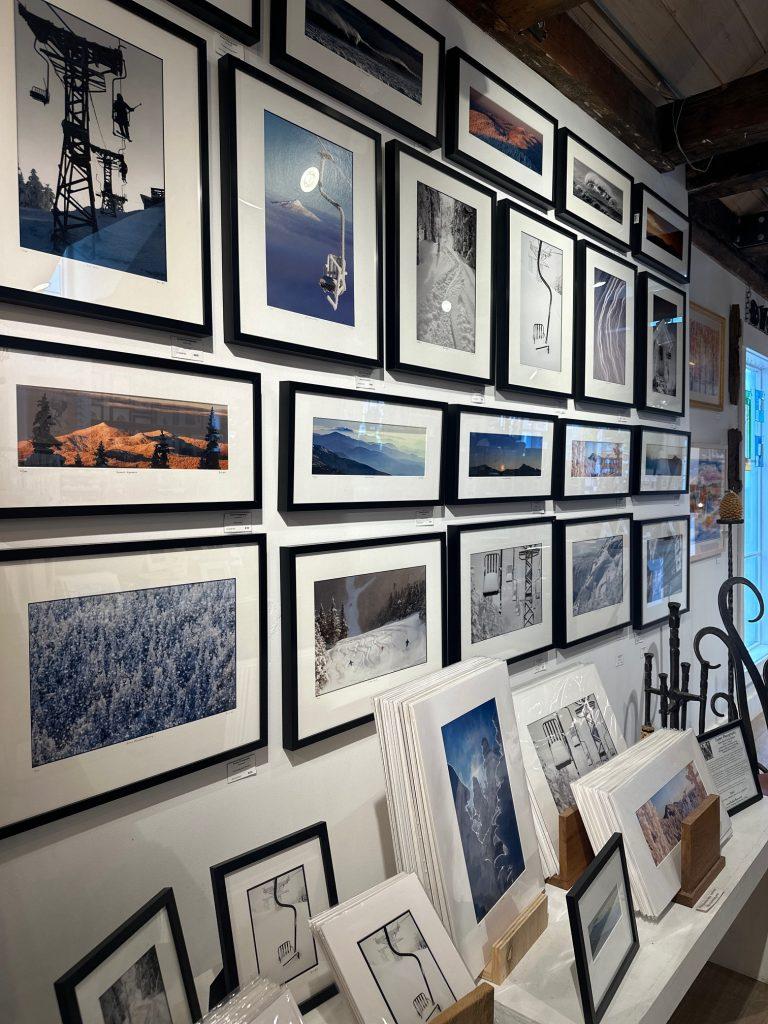 Framed photos and artwork displayed on a gallery wall.