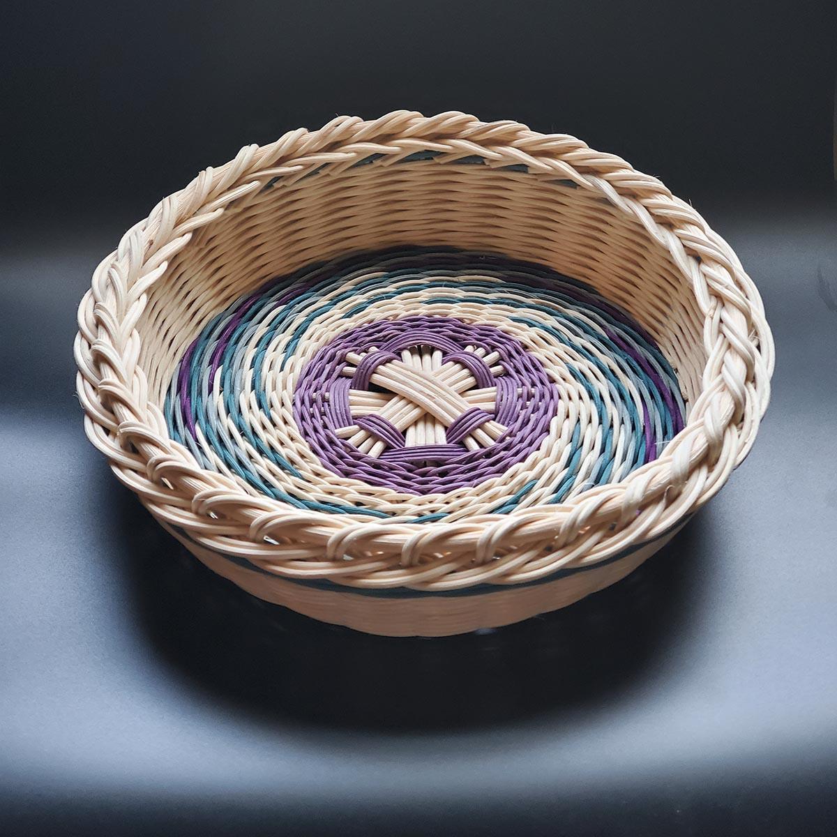 Round woven basket with colorful spiral pattern on the base.