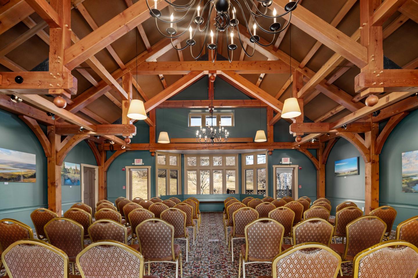 Rustic conference room with empty chairs and a vaulted wooden ceiling.