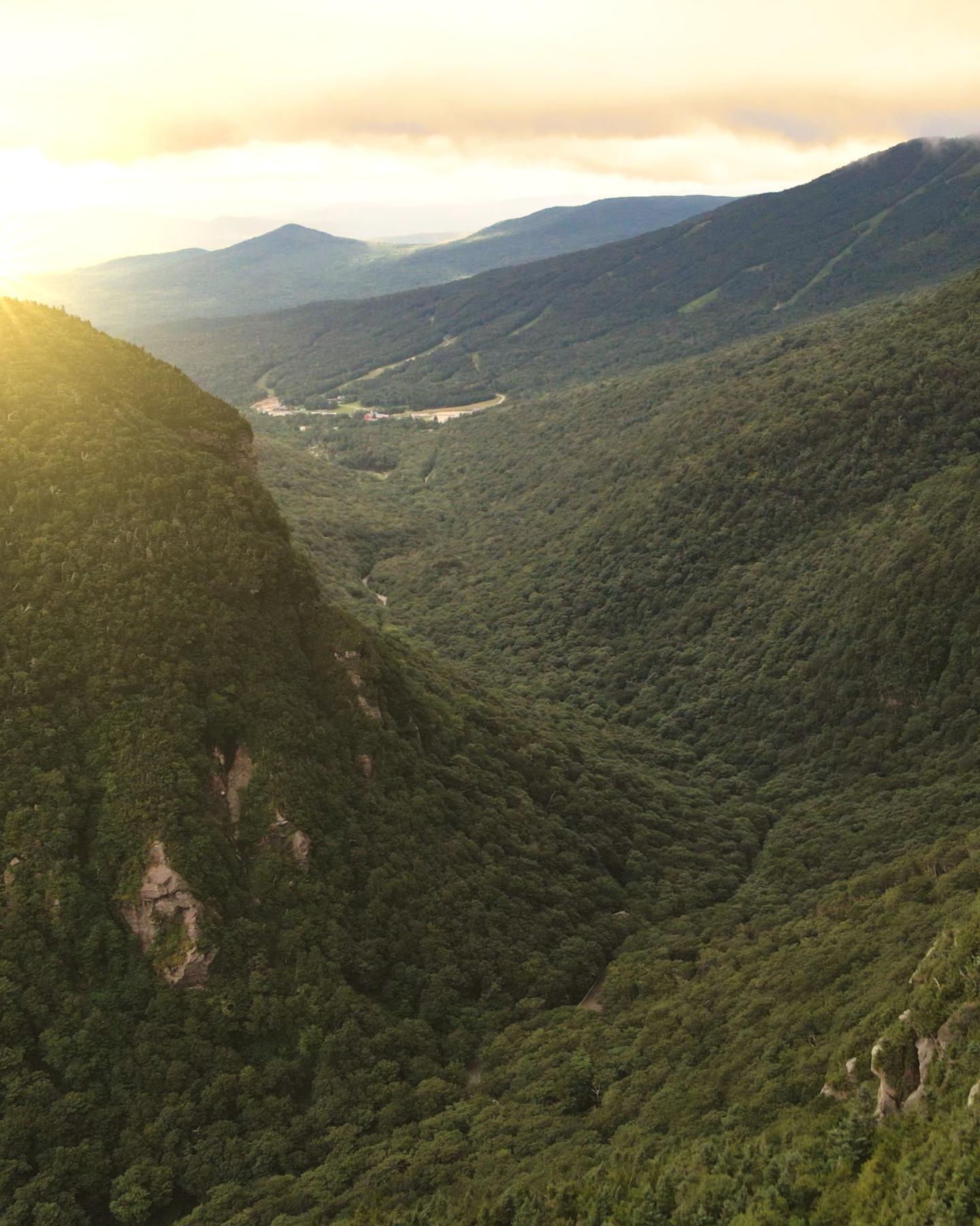 Sunrise over lush green mountain valley.