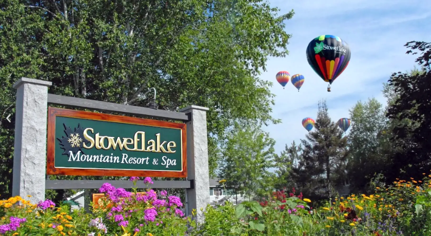 Sign for Stoweflake Mountain Resort with hot air balloons in the background.