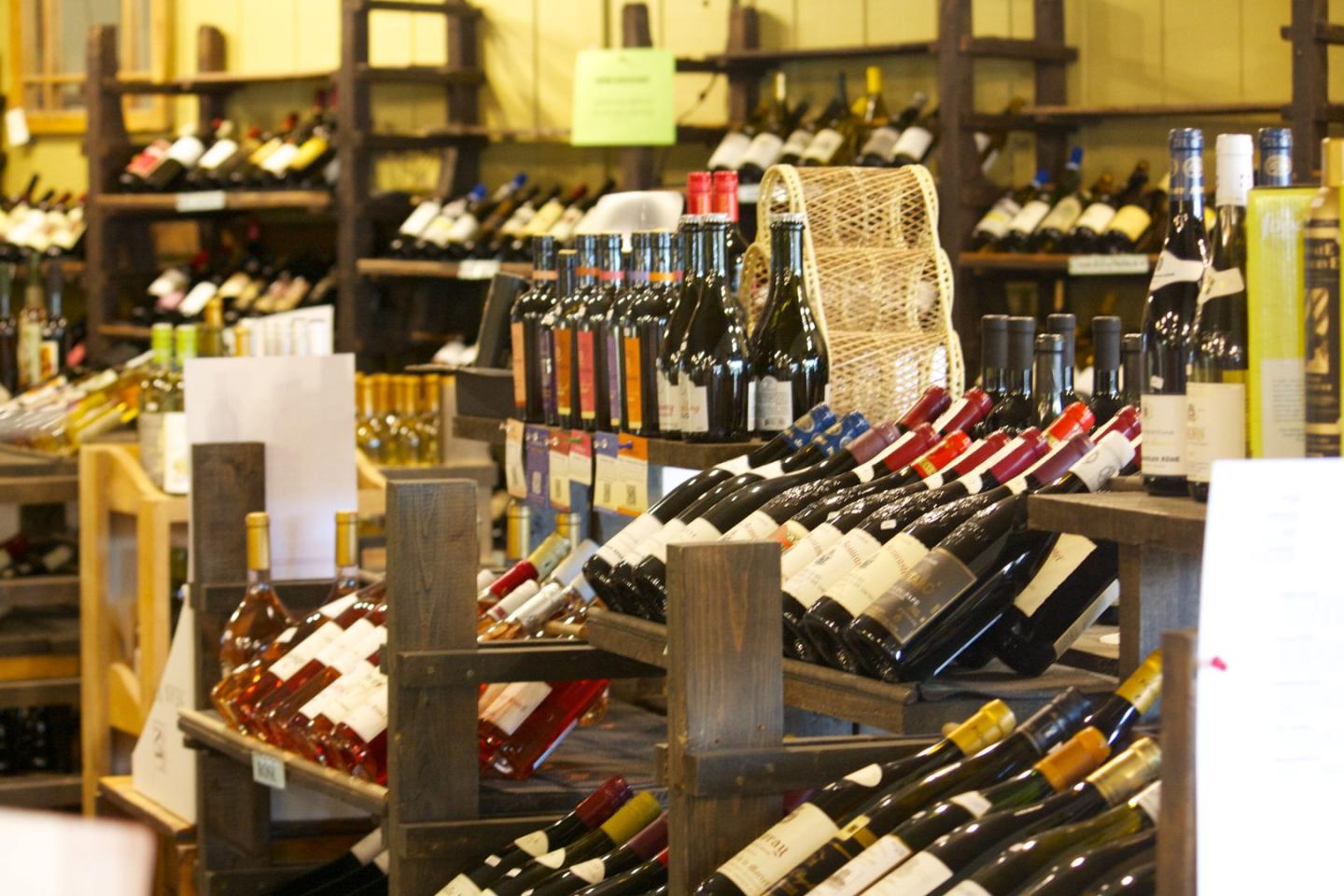 Wine bottles displayed on wooden shelves in a store.