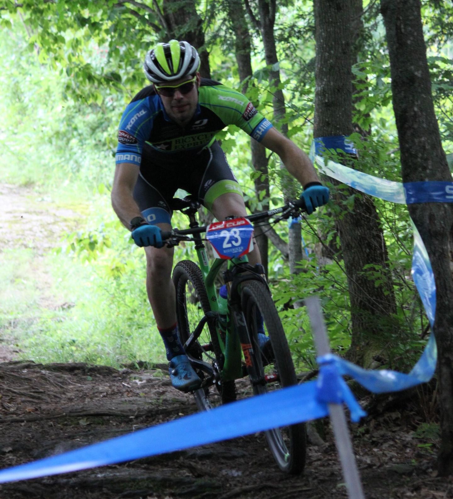 Cyclist racing through a forest trail.