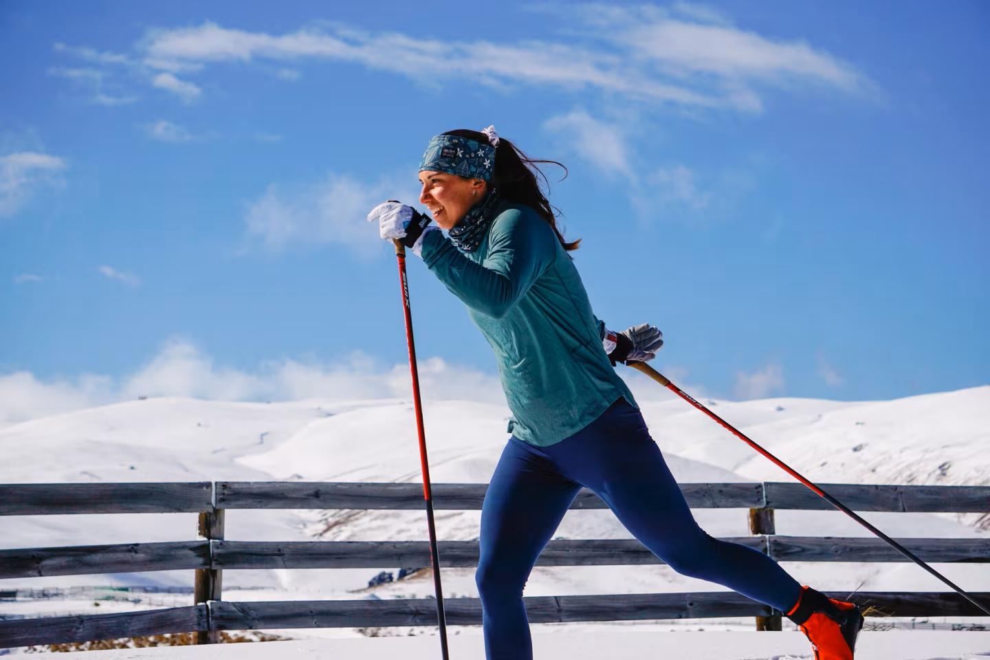 Cross-country skier in blue under a clear sky.