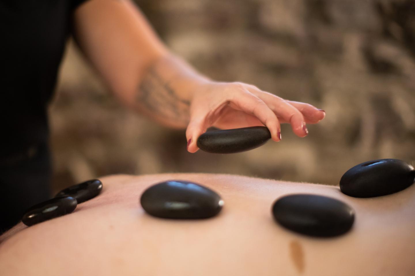 Hot stones being placed on a back during a massage therapy session.