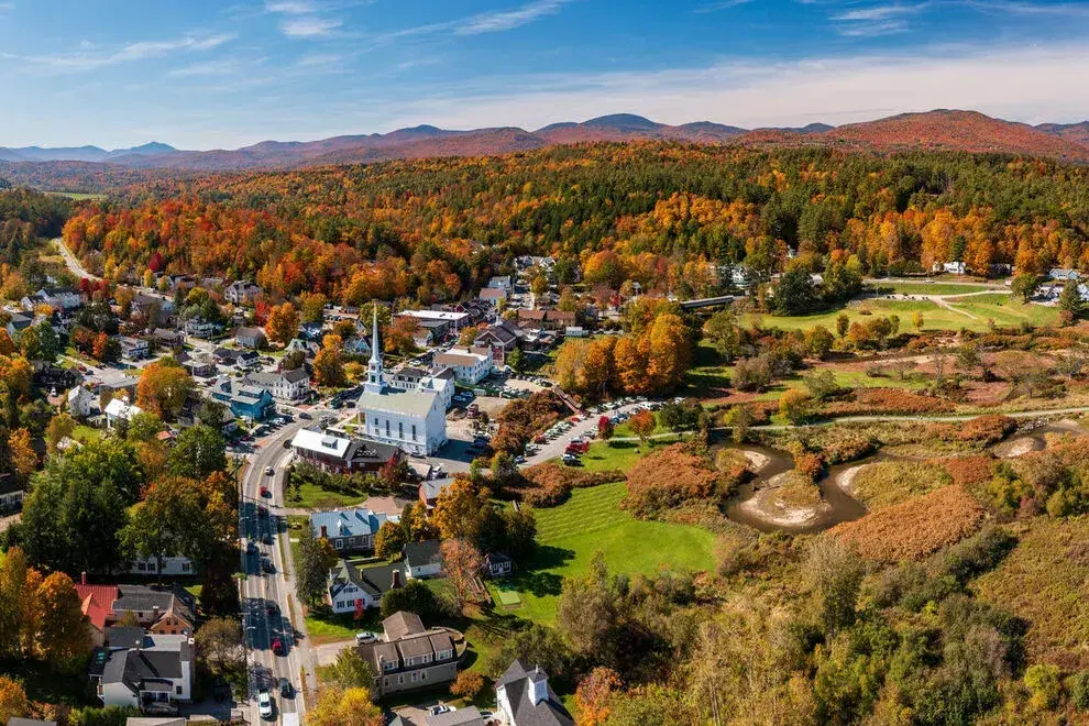 Small town in autumn, with colorful foliage and distant mountains.