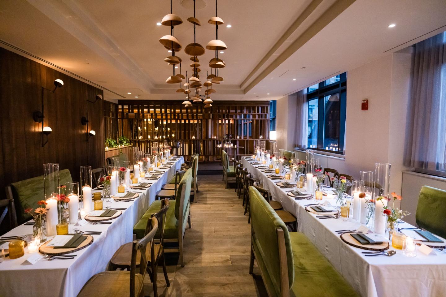 Elegant dining room set for a formal dinner with candles and green chairs.