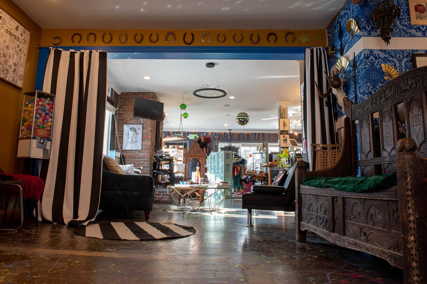 Eclectic room with colorful decor, striped curtains, and antique furniture.