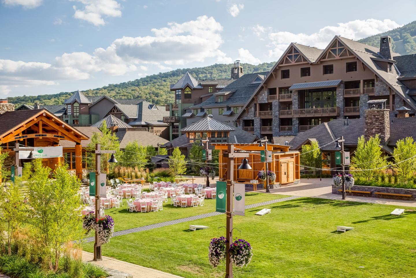 Mountain lodge with lush gardens and blue sky.