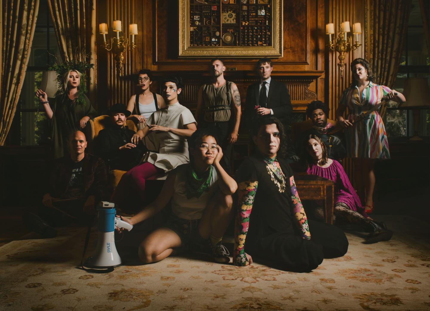 Elegant group portrait in a dimly lit, ornate room, varied expressions and poses.