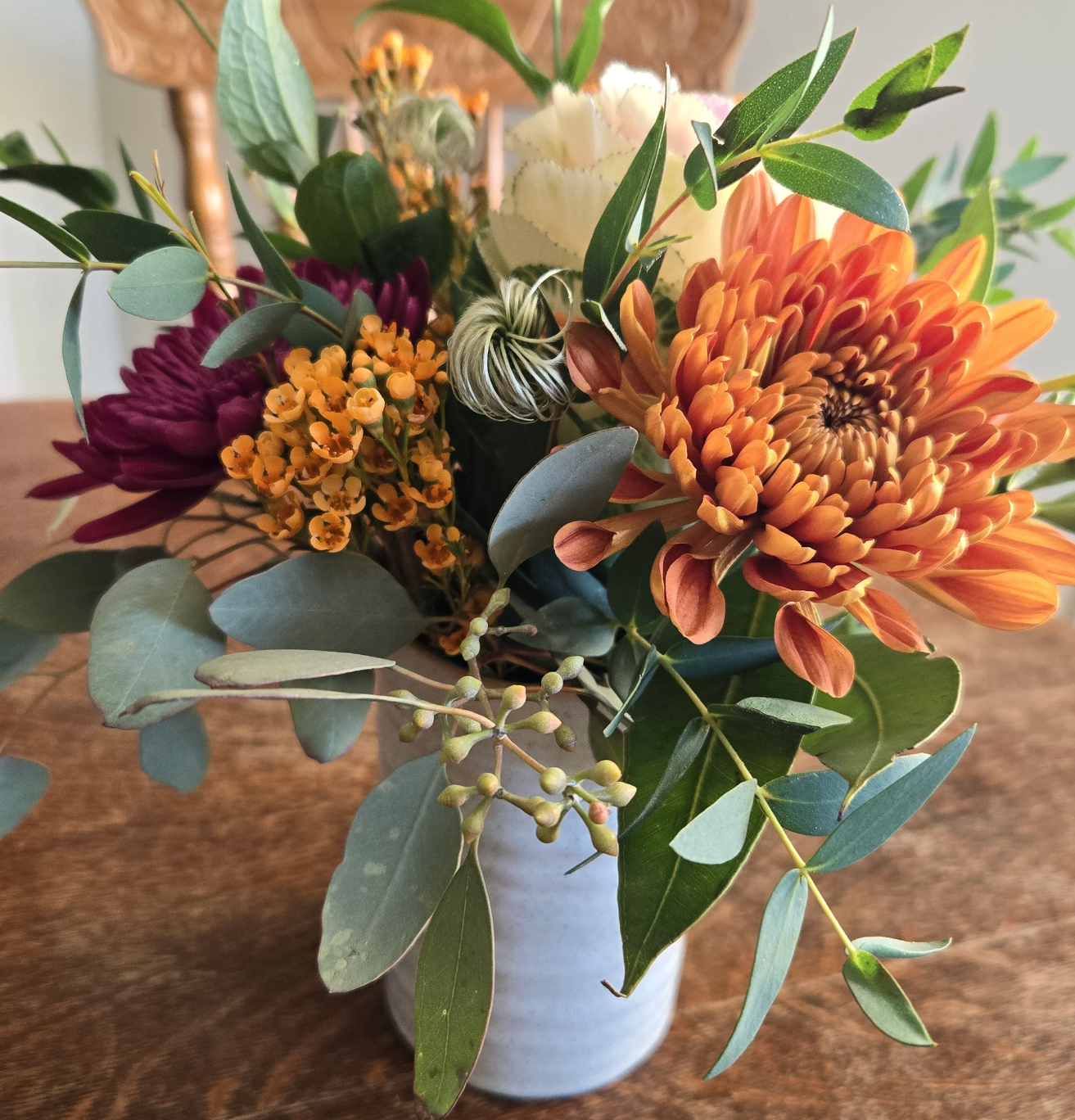 Colorful bouquet in a vase on wooden table.