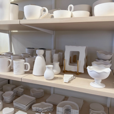White ceramic dishes and vases on wooden shelves.