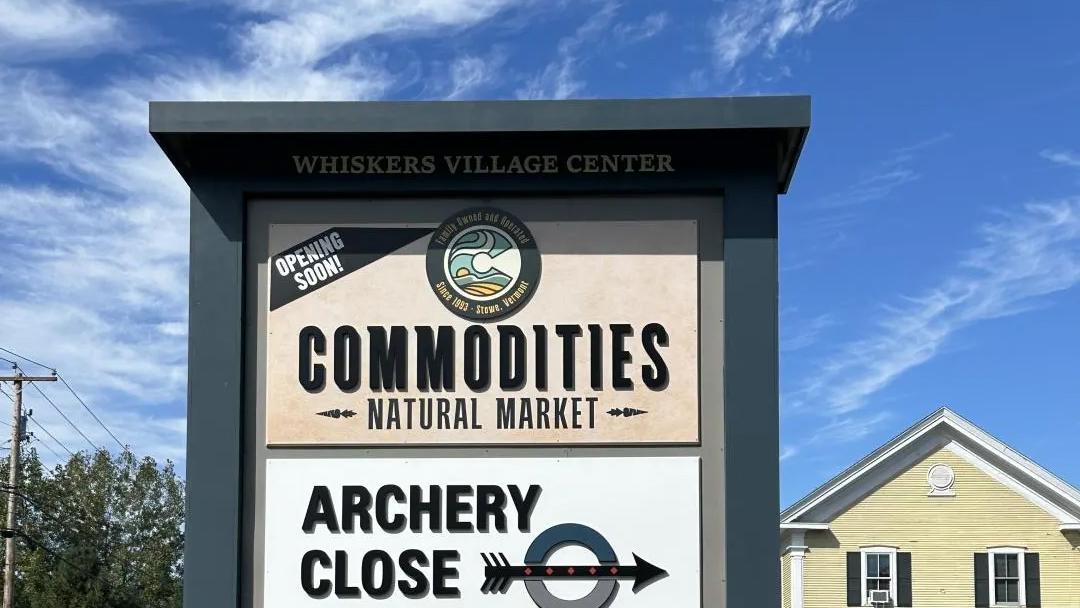 Sign for Commodities Natural Market under a clear blue sky.