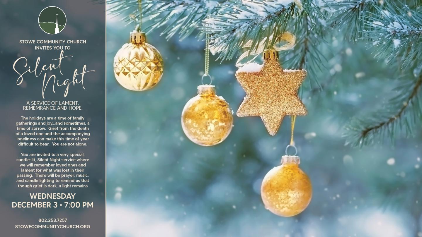 Golden ornaments hang on a snowy pine branch.