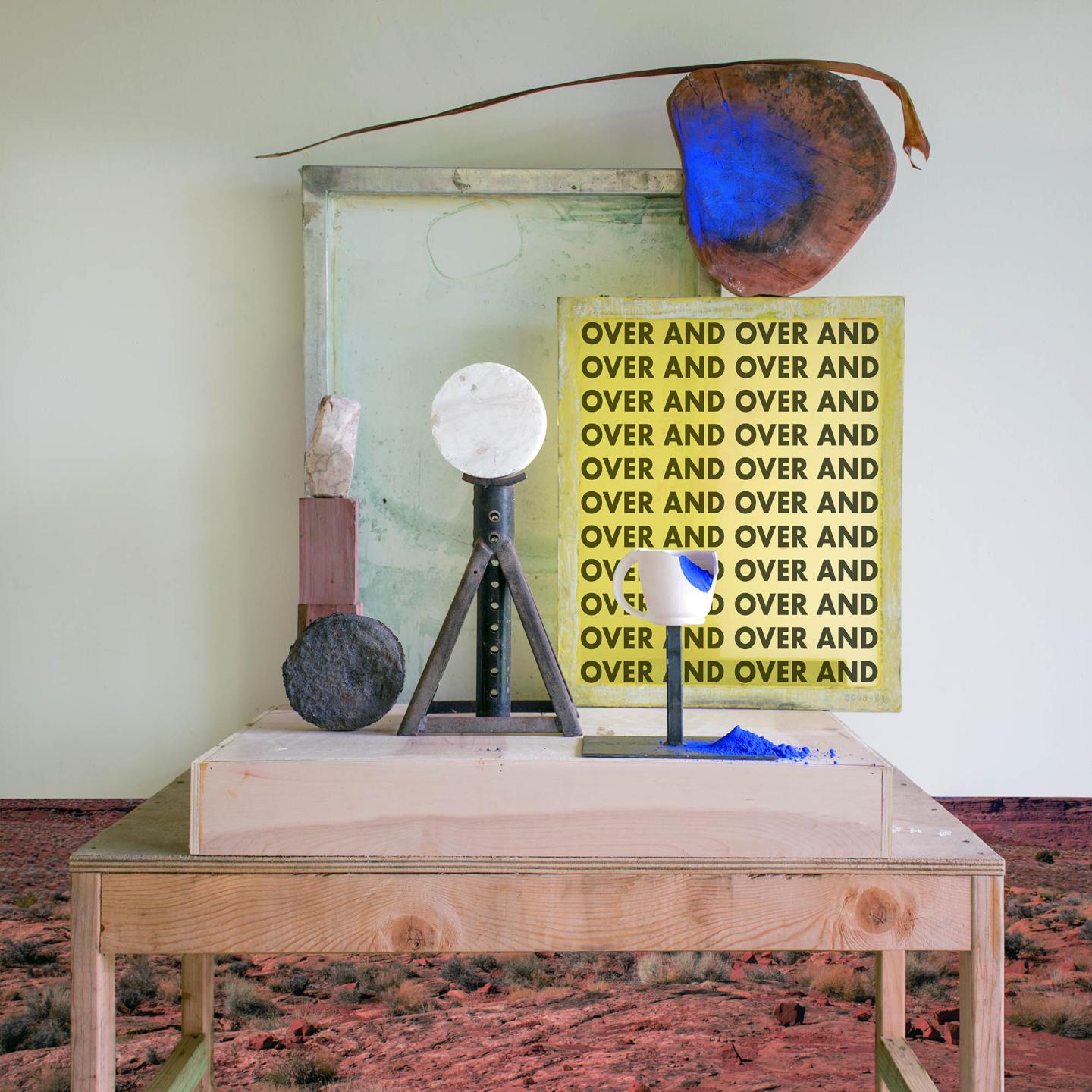 A table with abstract sculptures and art pieces displayed on top.