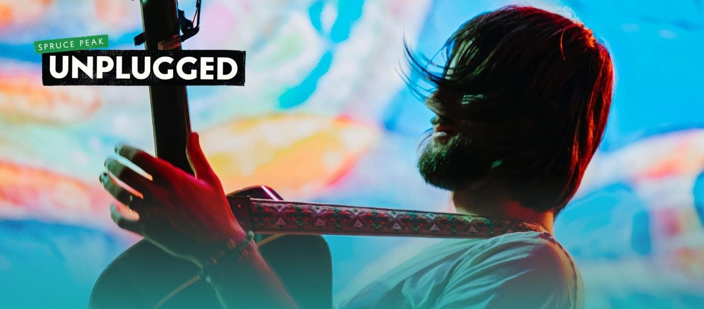Musician with guitar on colorful, abstract background.