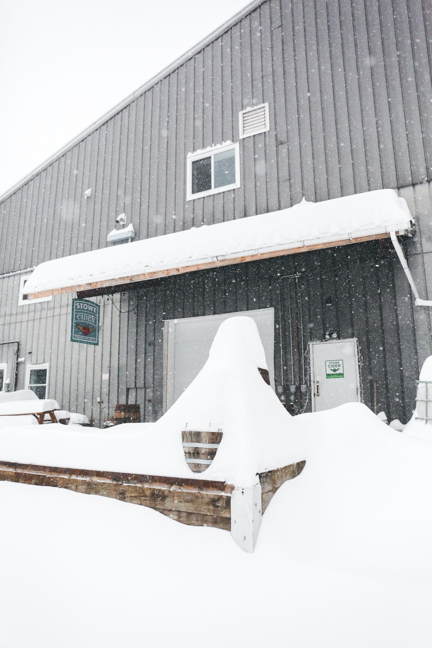 Building covered in heavy snow, with snow-drifts on roof and ground.