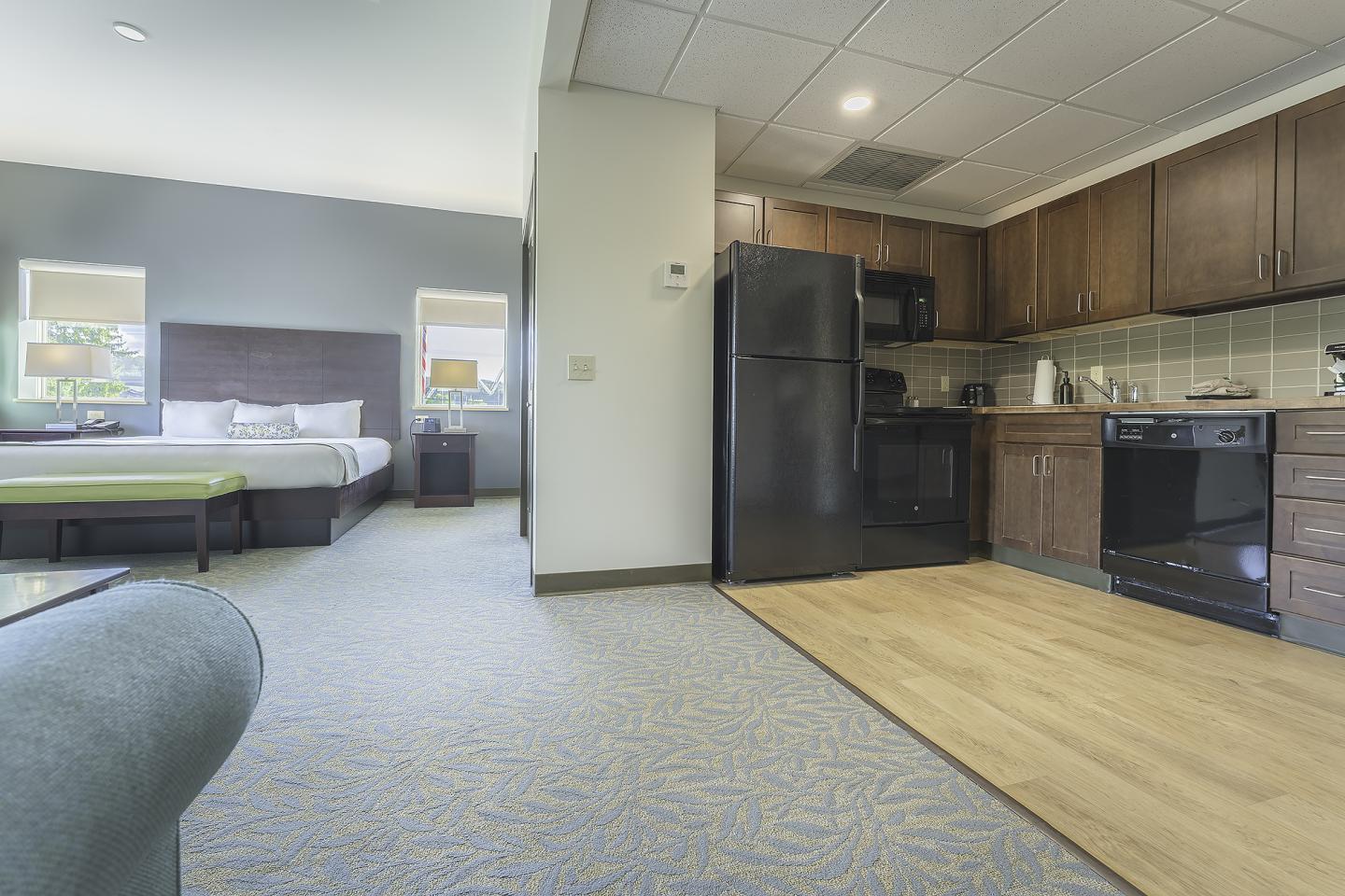 Hotel suite with a kitchenette and bedroom visible.