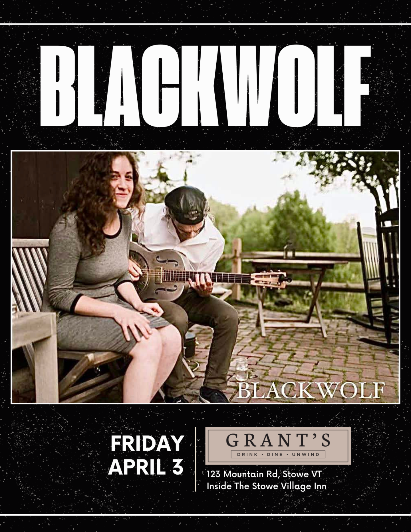 Man playing guitar next to a seated woman, outside on a patio.