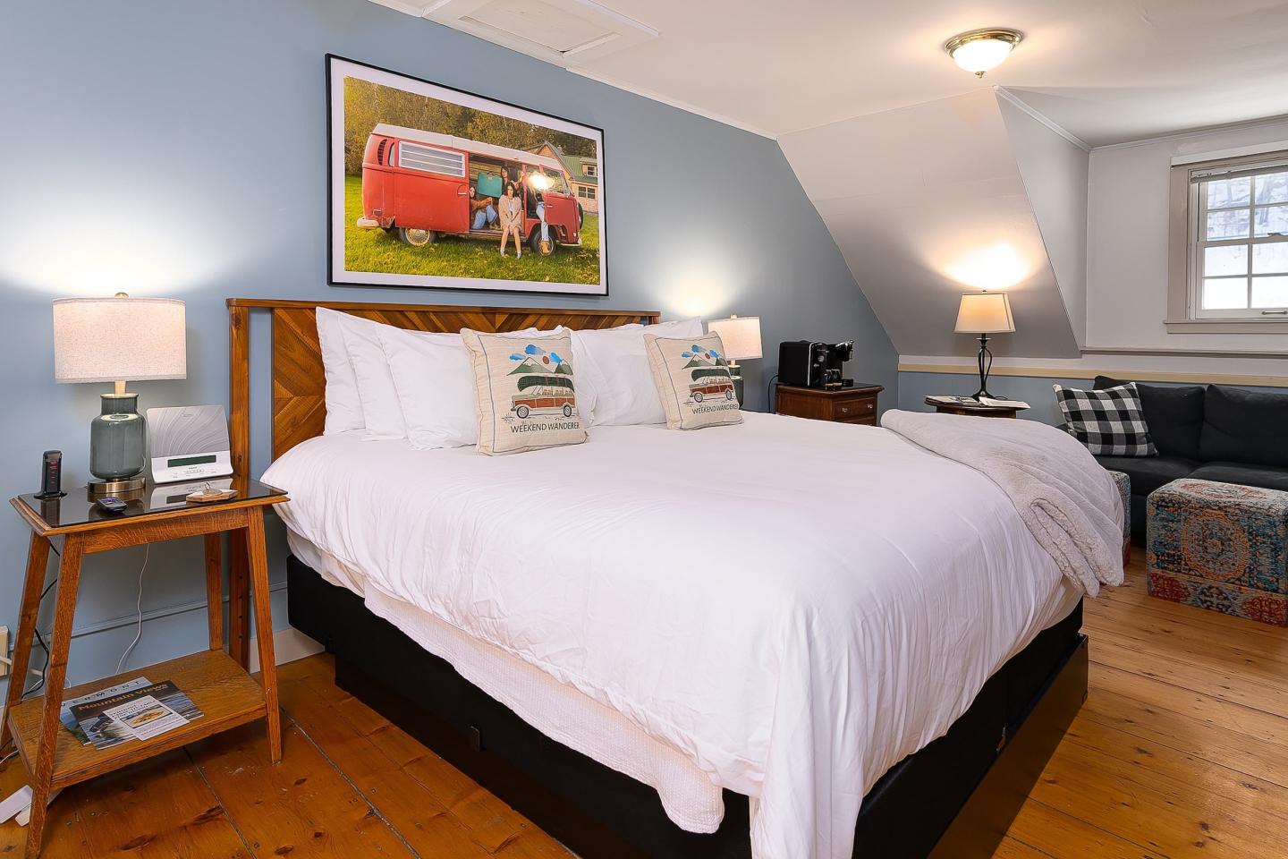 Bedroom with a large bed, blue walls, and warm lighting.
