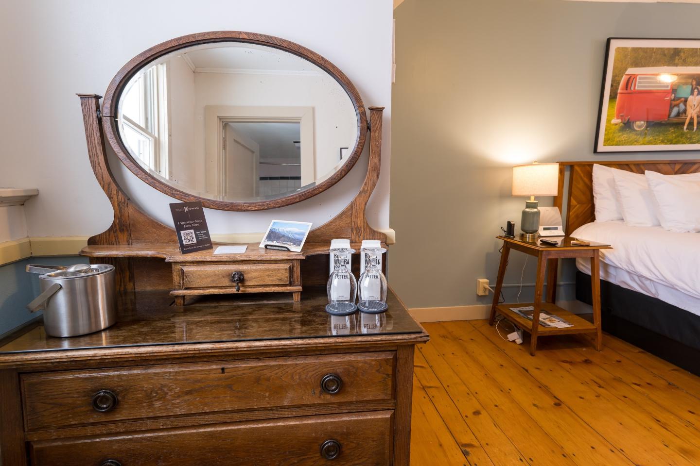 Vintage wooden dresser with mirror in a cozy bedroom setting.