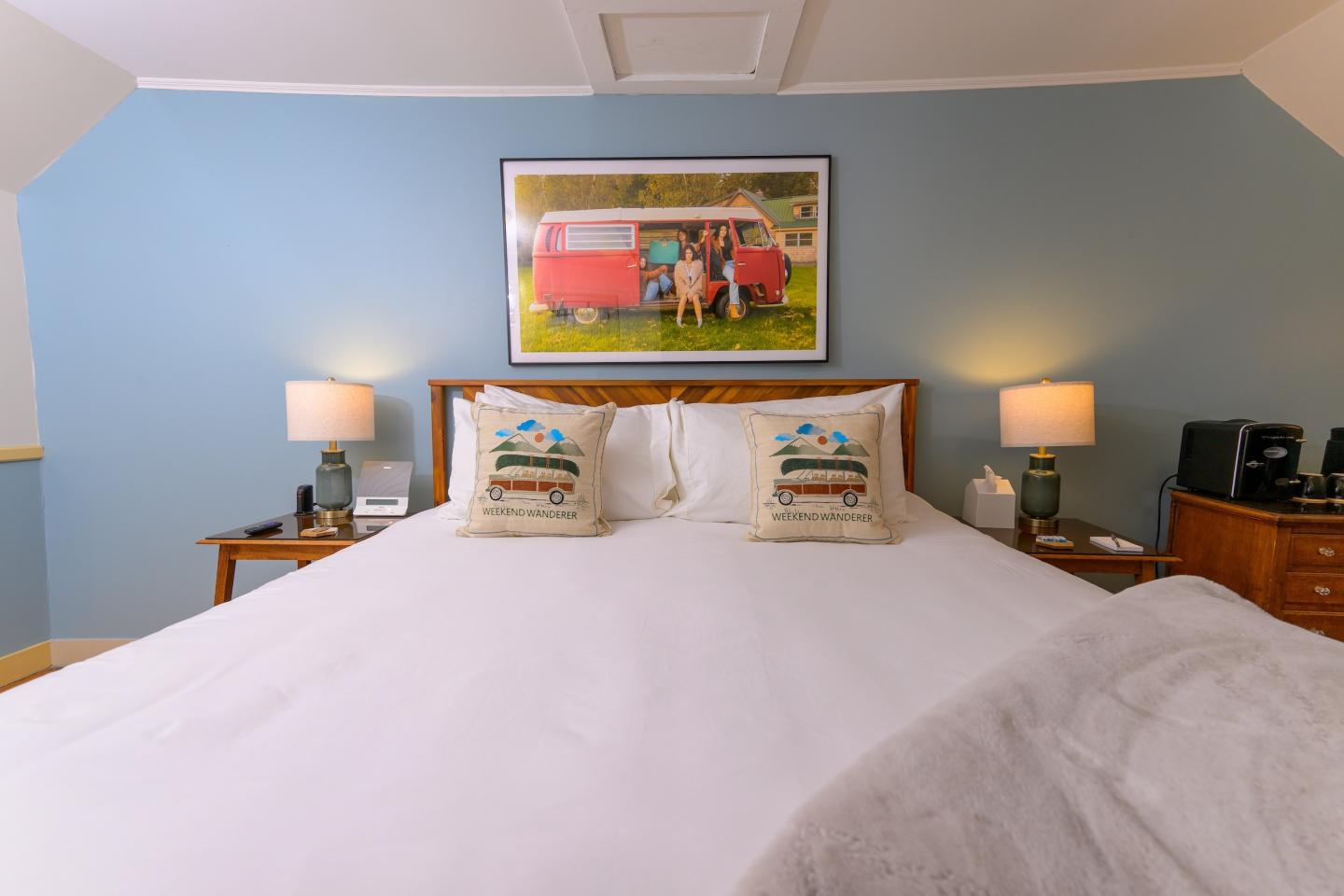 Cozy bedroom with blue walls, a large bed, and warm lighting.