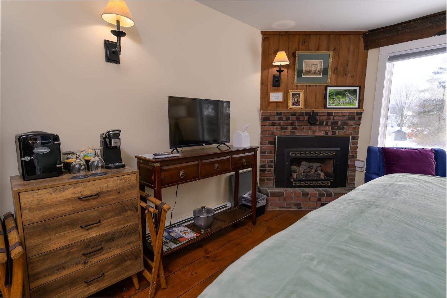 Cozy room with TV, fireplace, and wooden furniture.