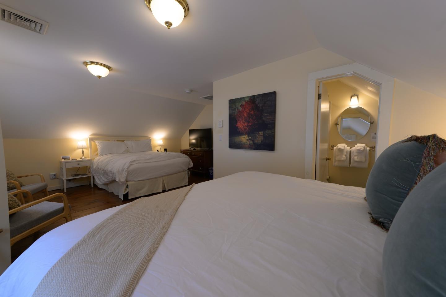 Cozy bedroom with two beds, soft lighting, and a small seating area.