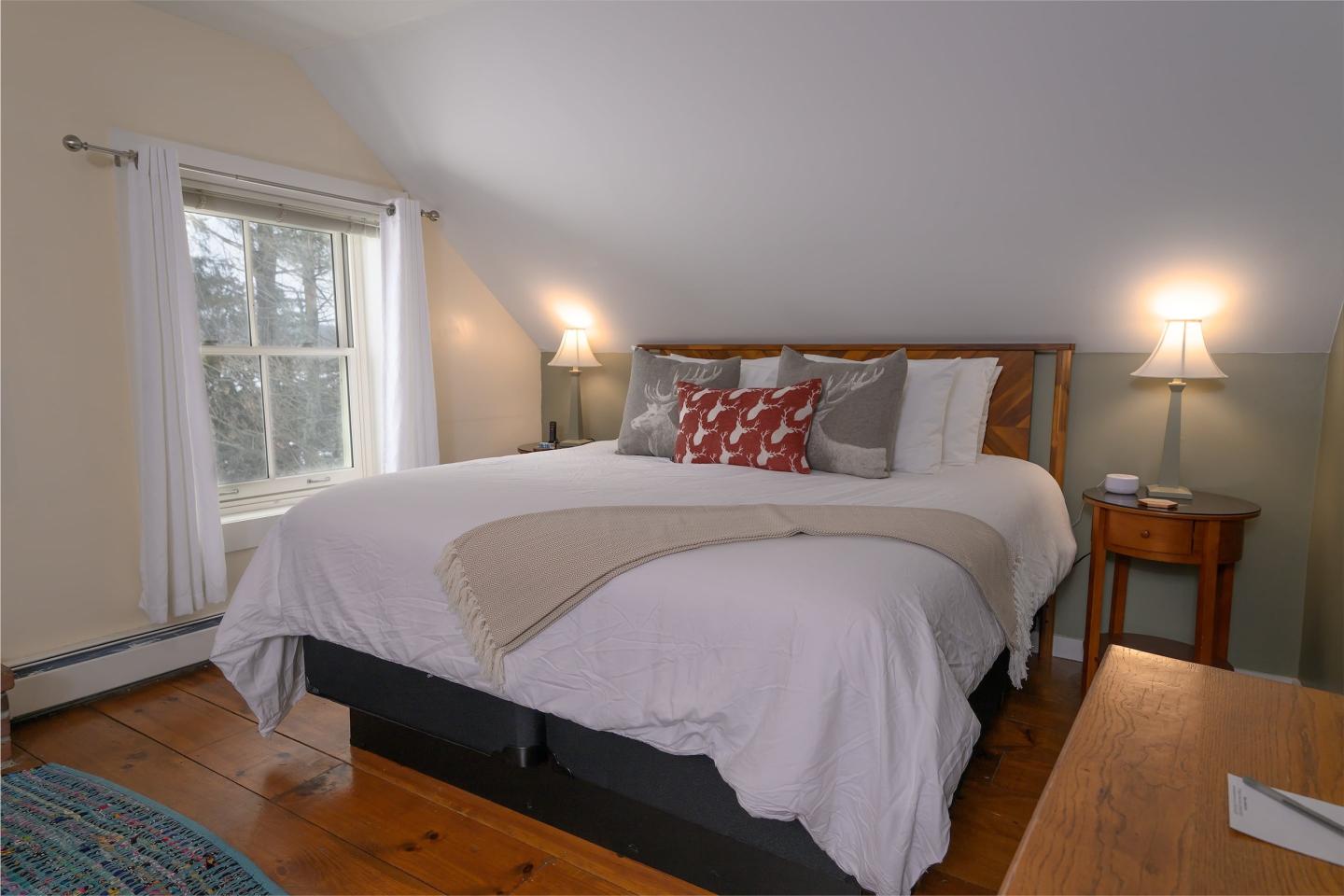 Cozy bedroom with a large bed, bedside lamps, and a window.