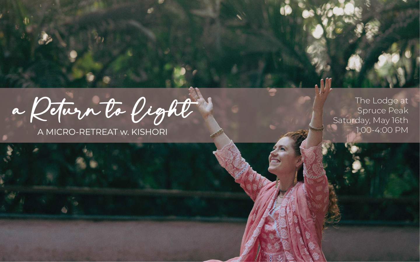 Woman in pink sitting outdoors with arms raised, smiling amid greenery.