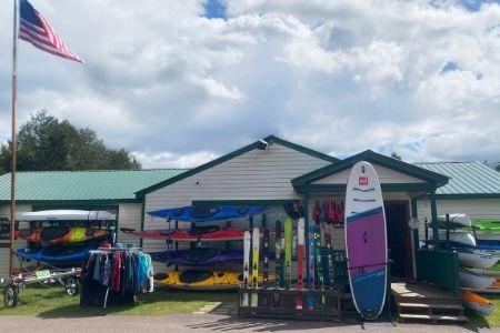 Boat and Skis displayed outside a Umiak shop with a flag and cloudy sky.