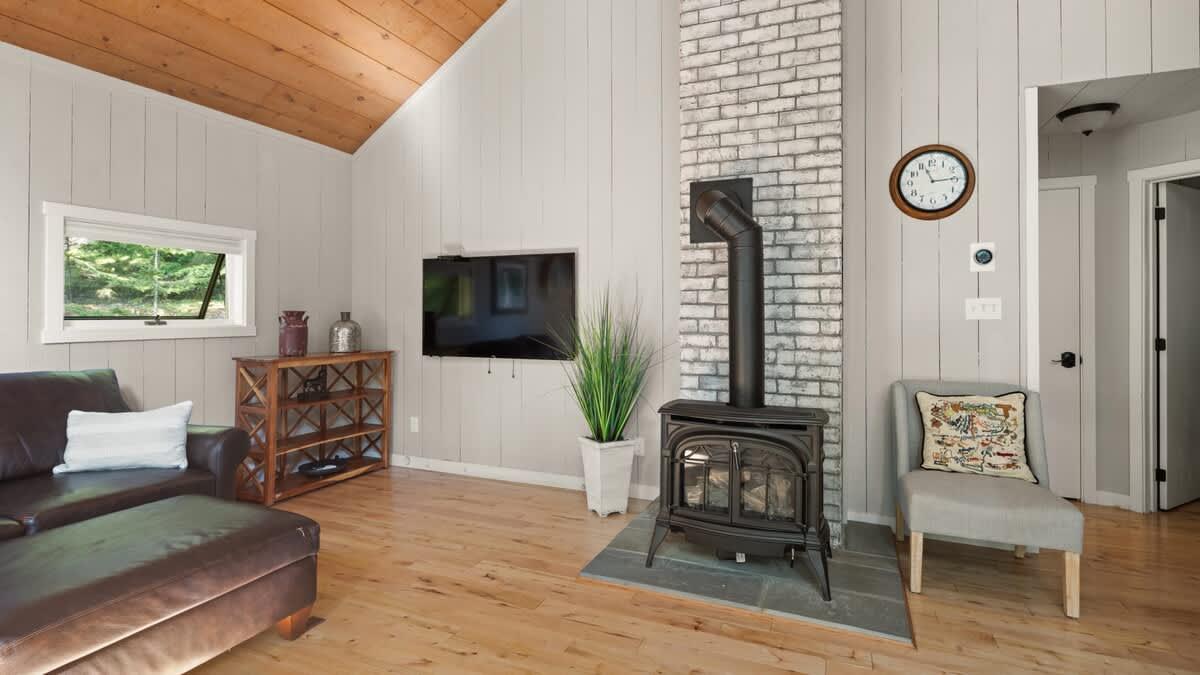 Cozy living room with wood stove, TV, and tan walls.