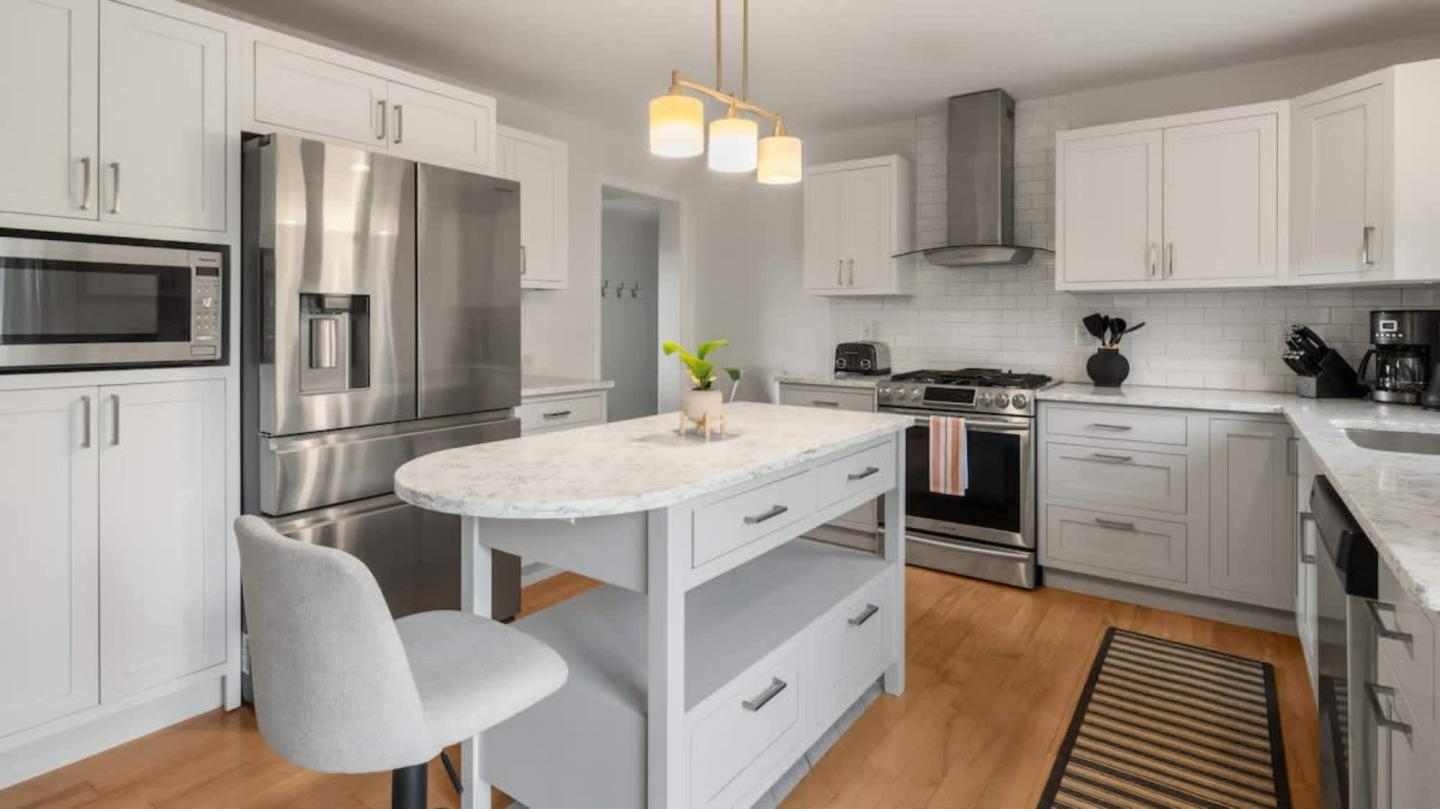 Modern kitchen with white cabinets, stainless steel appliances, and a center island.