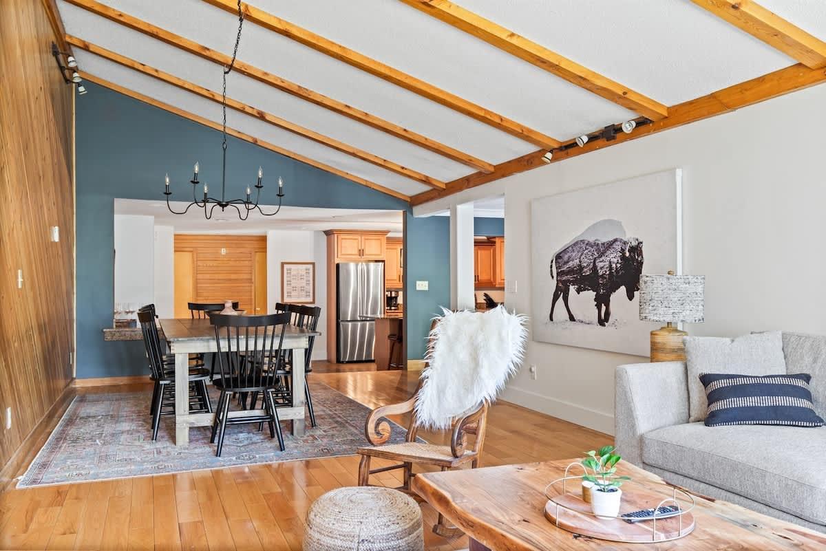 Cozy living room with dining area, wooden beams, and buffalo art.