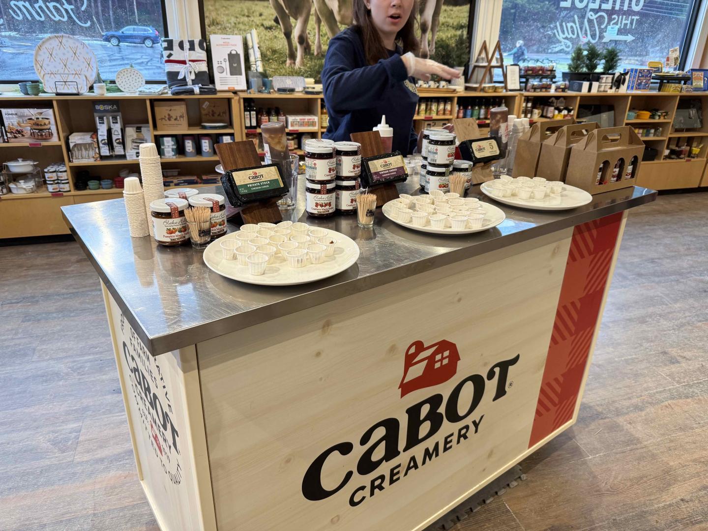 Cabot Creamery sampling booth with cheese platters and jars.