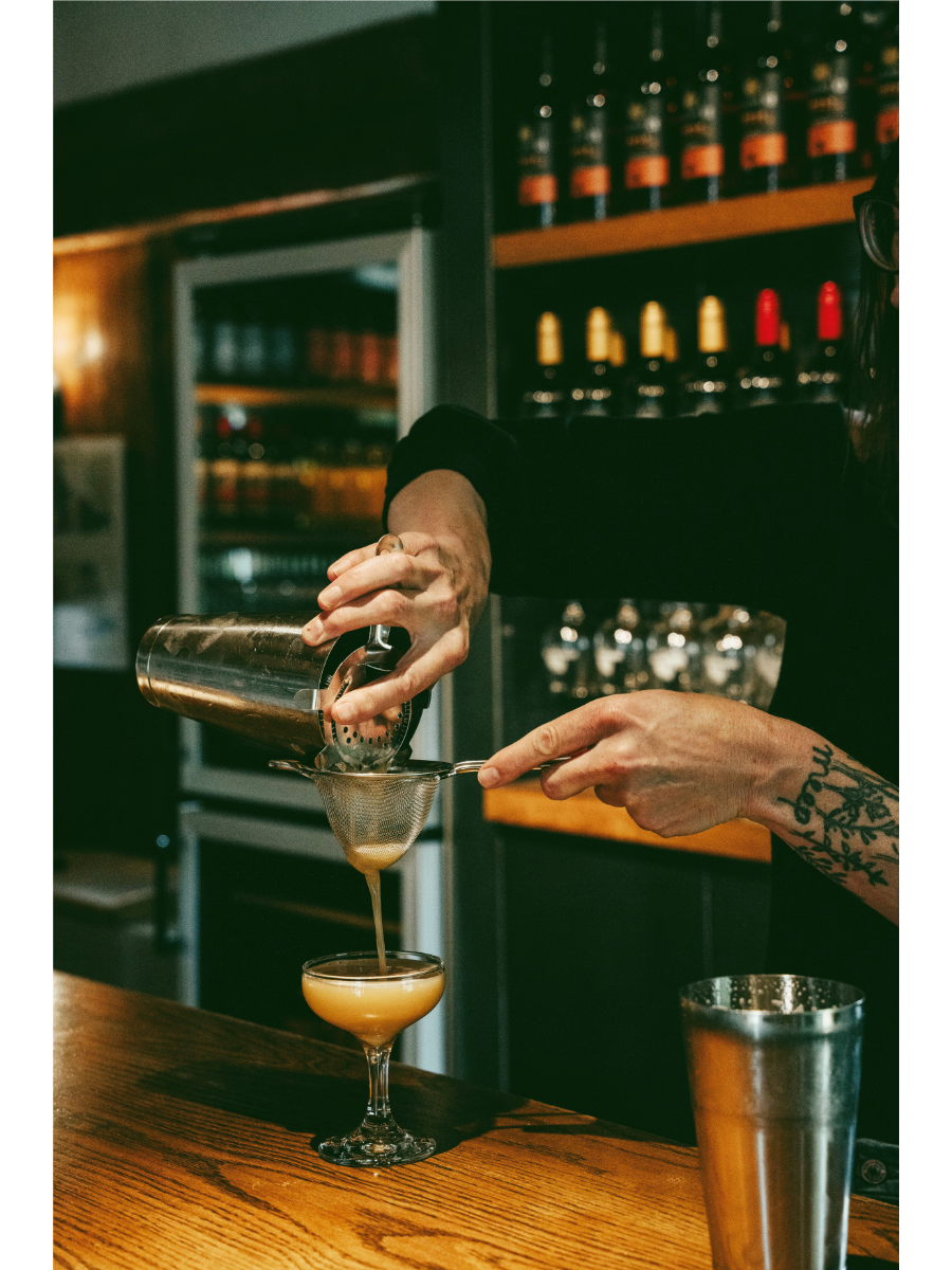 Bartender pouring an espresso martini in an elegant tasting room
