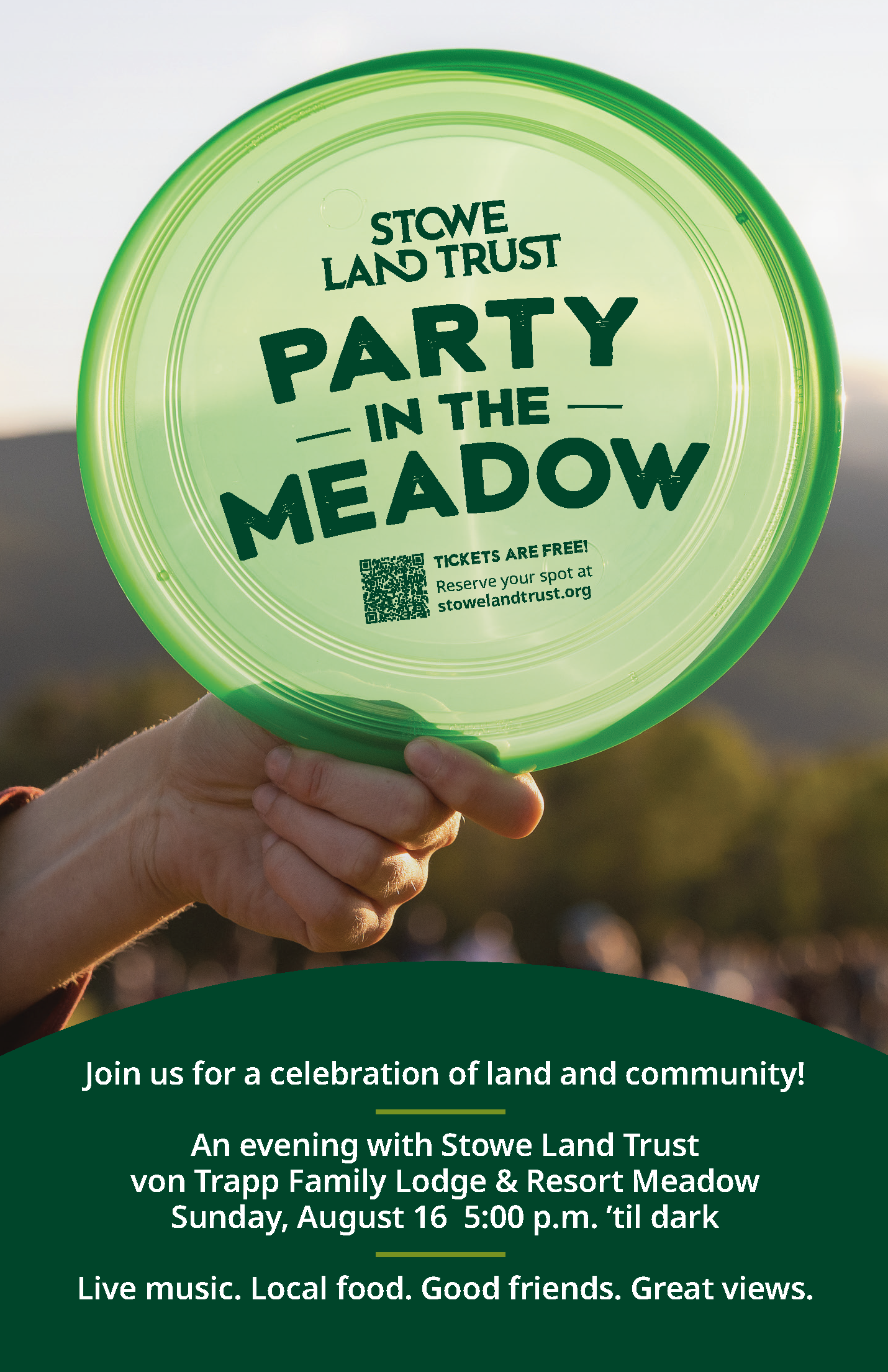 Green frisbee with "Party in the Meadow" text held outdoors at sunset.
