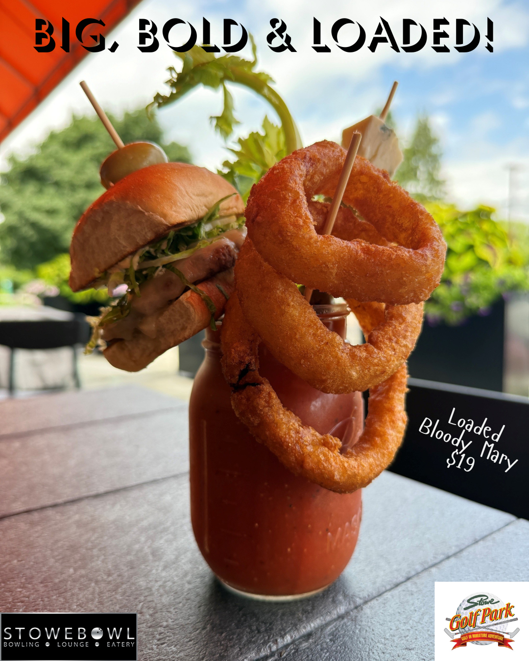 Bloody Mary with burger, onion rings, celery, and skewered appetizers in a mason jar.