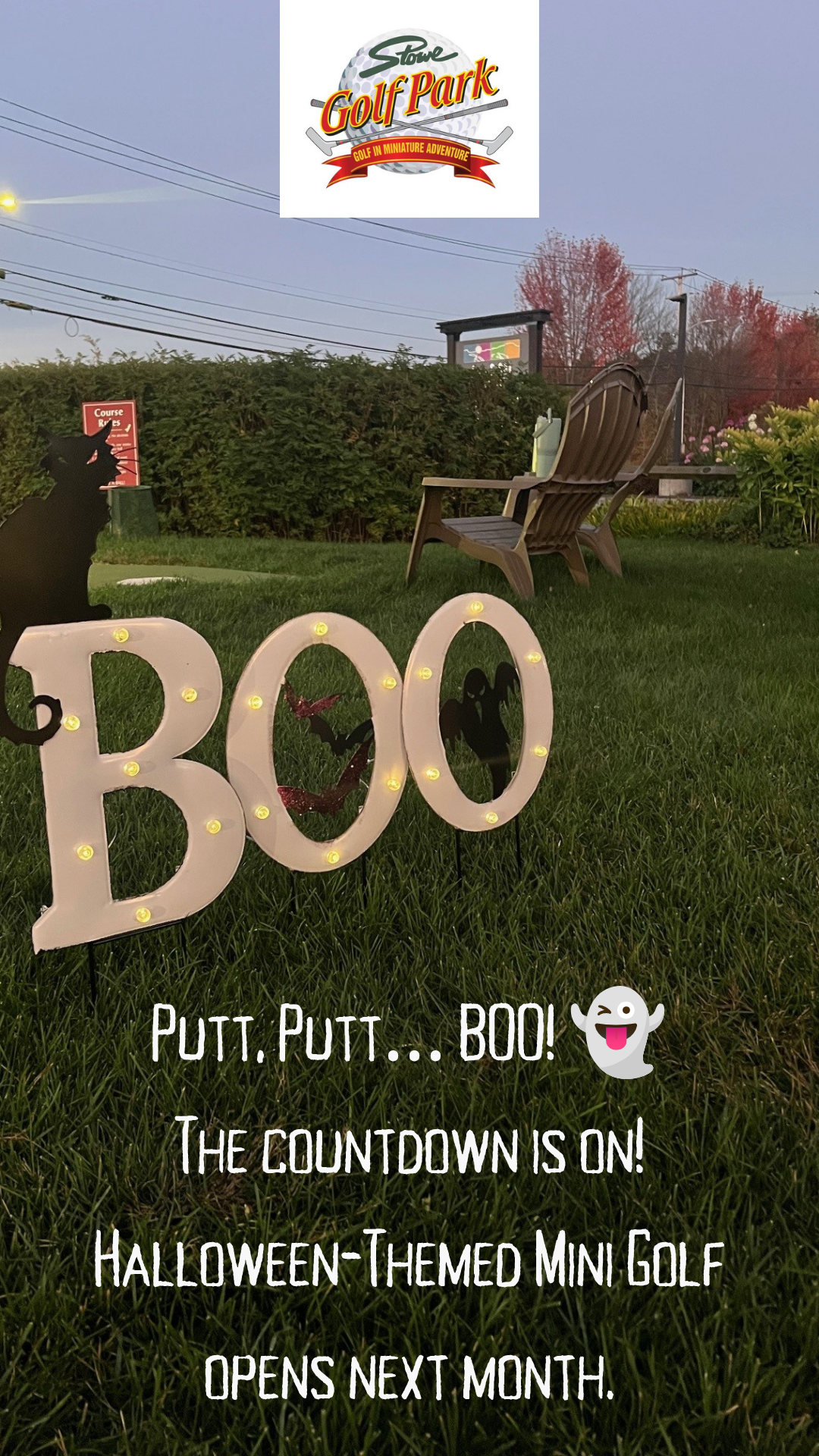 Halloween-themed mini golf course at dusk with "BOO" sign.